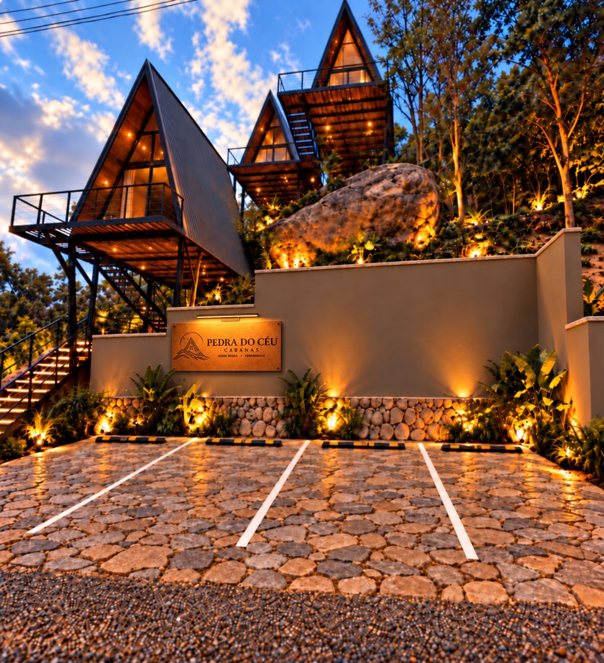 Imagem ilustrativa do projeto: fachada noturna da Pedra do Céu Cabanas, com as três cabanas A-frame iluminadas e a placa de entrada