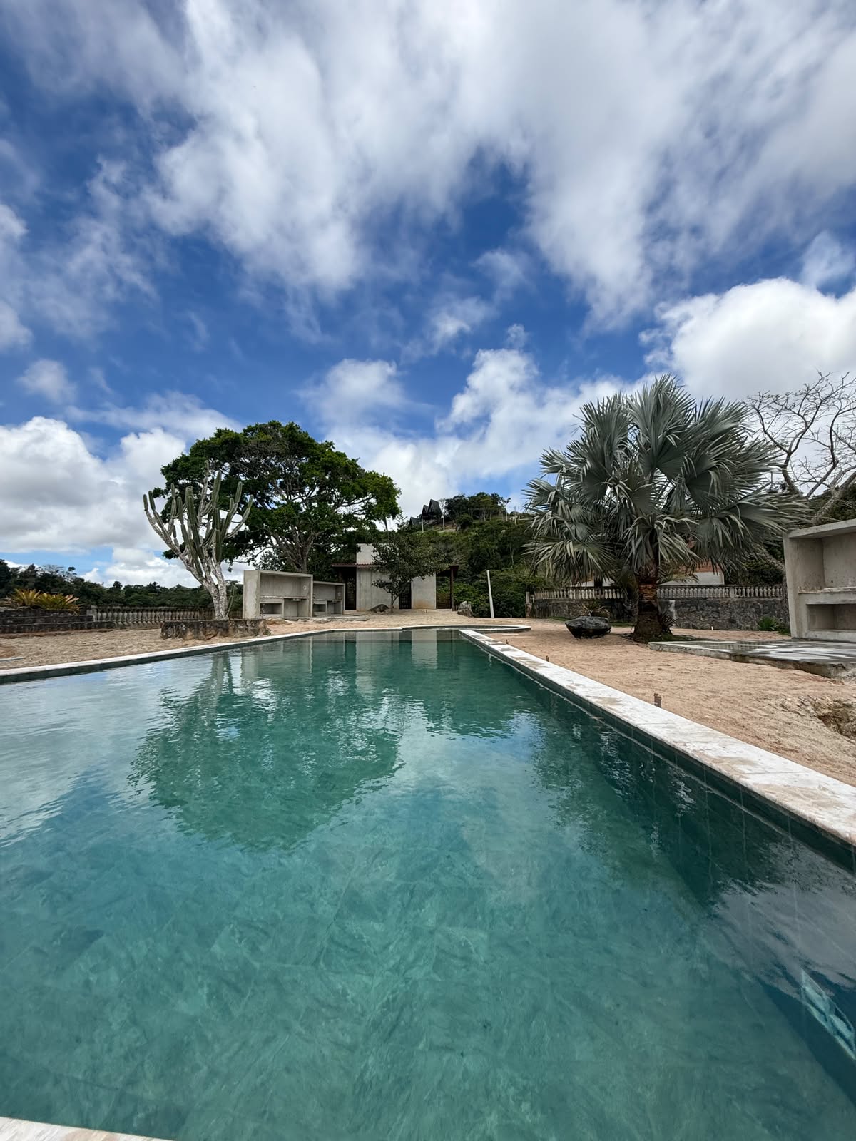 Piscina retangular do Condomínio Reserva Serra Negra, em dia de céu azul