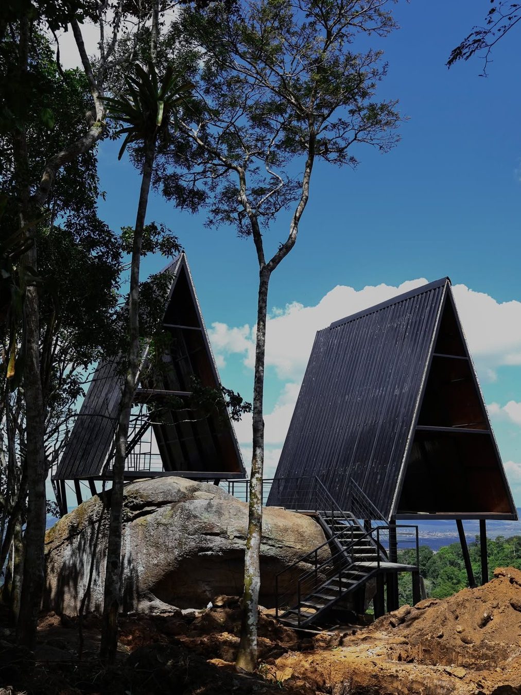 Duas cabanas A-frame tomando forma sobre a rocha, em obra (outubro de 2026)